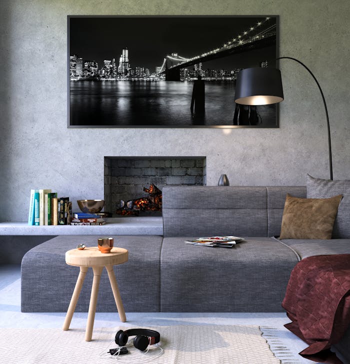 brand-02 Modern gray living room featuring a fireplace and cityscape artwork, creating a cozy ambiance.
