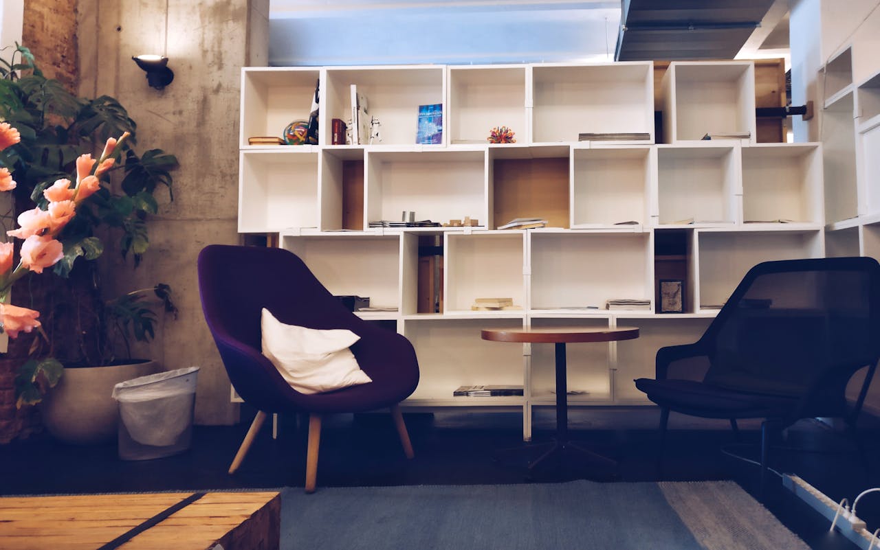 creative-03 A stylish living room featuring modern furniture, bookshelves, and decorative plants.