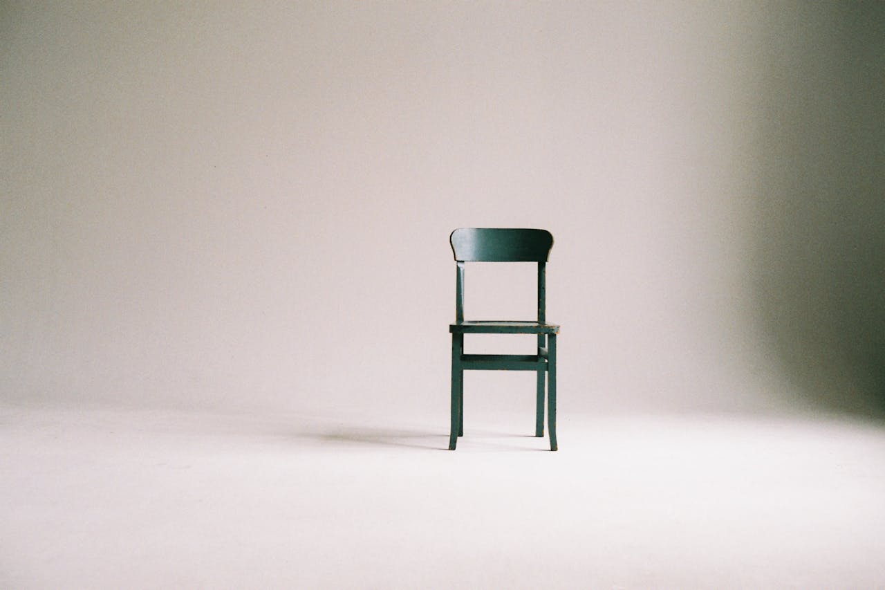 Services-03 A single black chair in a minimalistic studio setting with a neutral backdrop.